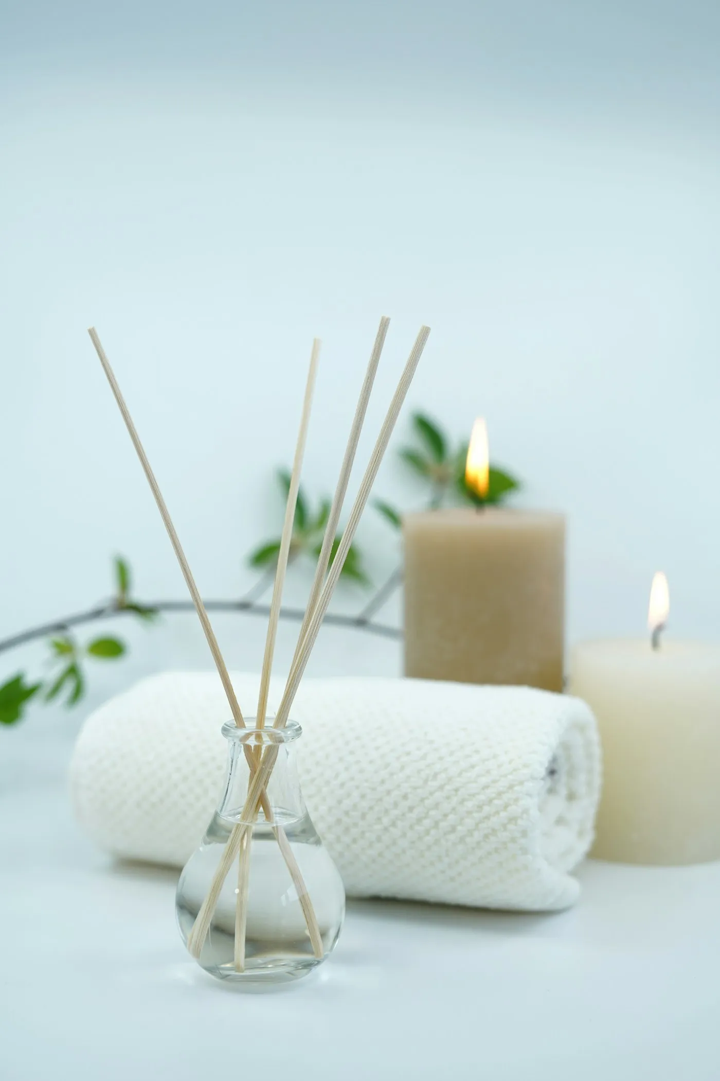 Toalha enrolada, velas acesas e difusor de aromas